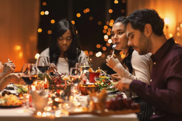 Amigos felices teniendo la cena de Navidad en casa —  Fotos de Stock