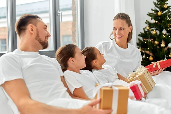 Heureux famille avec des cadeaux de Noël au lit à la maison — Photo
