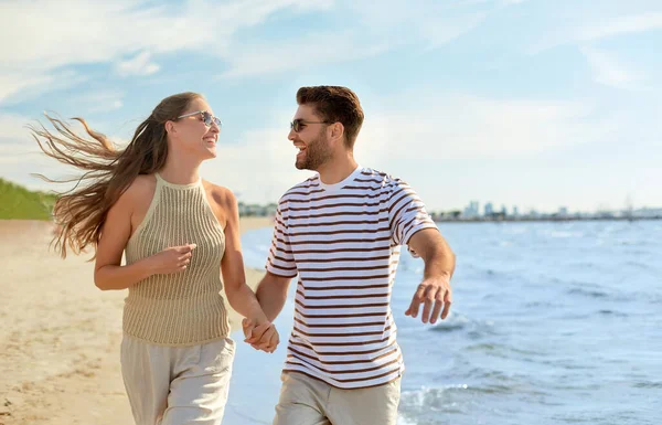 快乐的夫妻在夏天的海滩上奔跑 — 图库照片