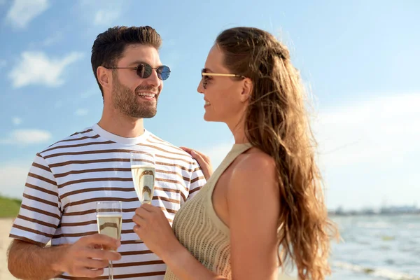 Feliz pareja bebiendo champán en verano playa —  Fotos de Stock