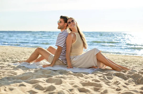 Feliz casal sentado de volta para trás na praia de verão — Fotografia de Stock