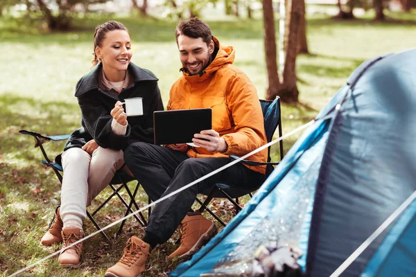 Pareja con tableta pc beber té en el campamento de la tienda — Foto de Stock