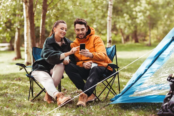 Couple avec smartphone buvant du thé au camping — Photo