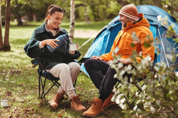 Happy couple drinking tea at tent camp — Stock Photo, Image