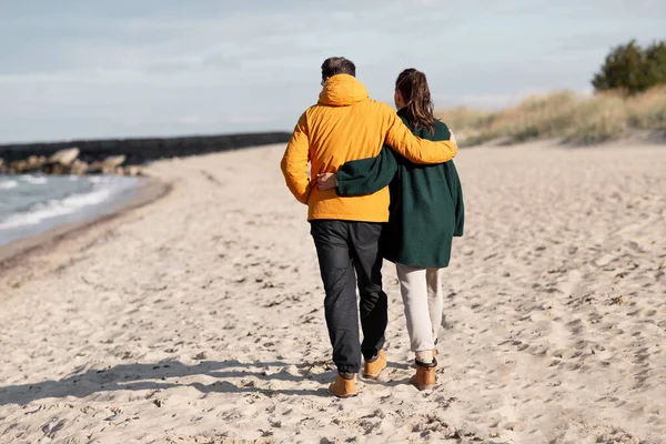 Пара прогулки вдоль осеннего пляжа — стоковое фото