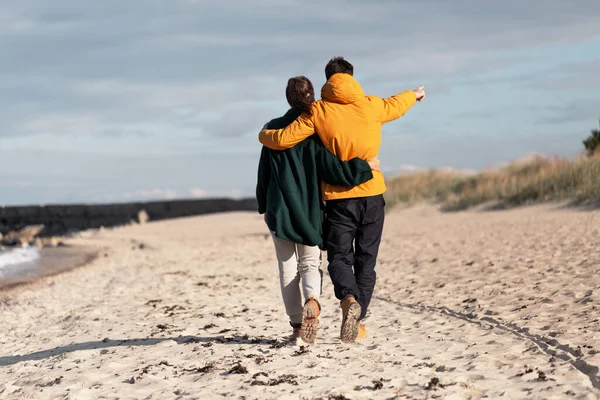 Casal andando ao longo da praia de outono — Fotografia de Stock