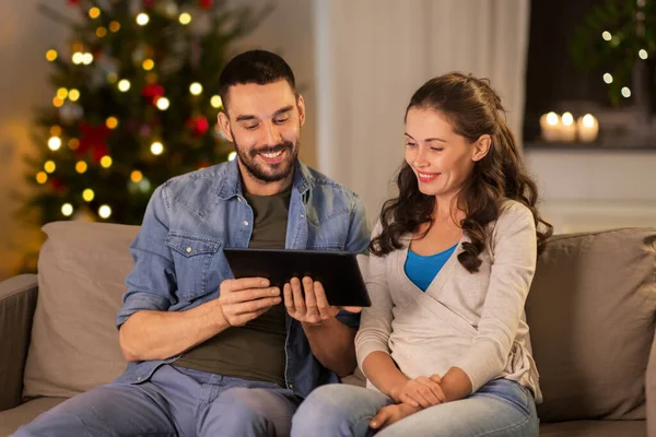 Glückliches Paar an Weihnachten mit Tablet-PC zu Hause — Stockfoto