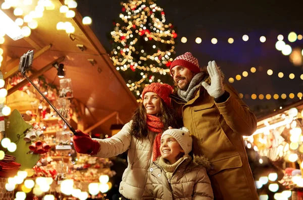 Mutlu aile Noel pazarında selfie çekiyor. — Stok fotoğraf