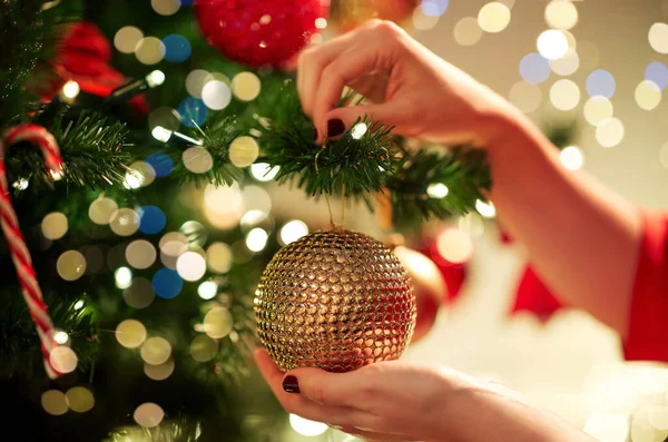 Mains décorant arbre de Noël avec boule — Photo
