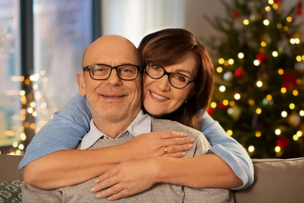 Felice coppia anziana che si abbraccia a casa a Natale — Foto Stock