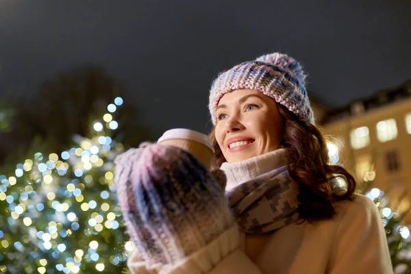 Femme heureuse buvant du café pendant les lumières de Noël — Photo