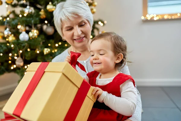 Großmutter und kleines Mädchen mit Weihnachtsgeschenk — Stockfoto