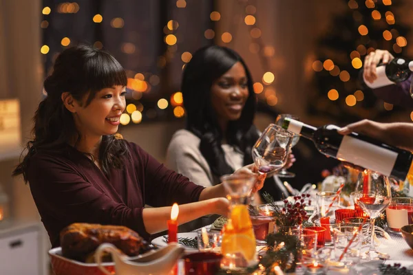 Gelukkig vrienden drinken wijn op kerstfeest — Stockfoto