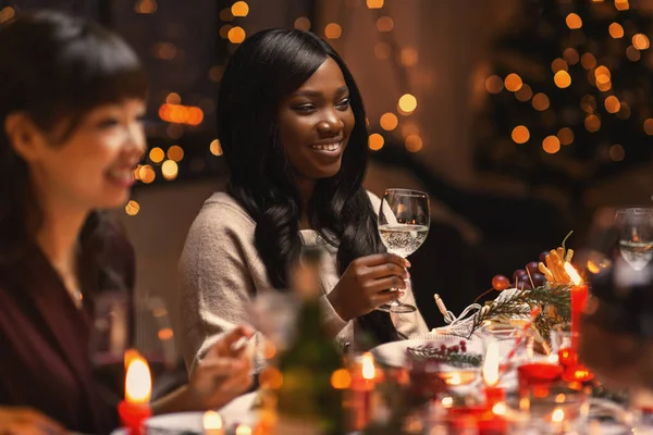 Amigos felices bebiendo vino en la fiesta de Navidad —  Fotos de Stock