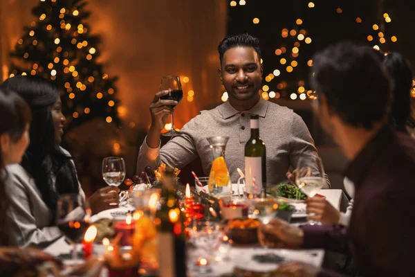 Boldog barátok bort isznak a karácsonyi partin — Stock Fotó