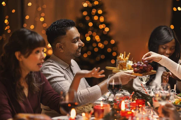 Amigos felices teniendo la cena de Navidad en casa — Foto de Stock