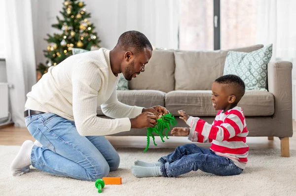 幸せな父親は家でクリスマスに息子と遊ぶ — ストック写真