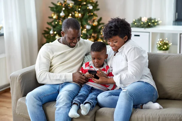 Afrikai család telefonnal karácsonykor otthon — Stock Fotó