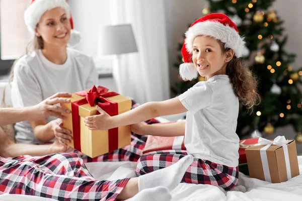 Szczęśliwa rodzina z prezentów świątecznych w łóżku w domu — Zdjęcie stockowe