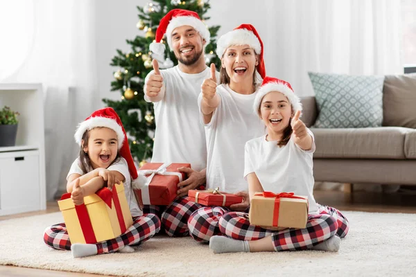 Happy family sitting under christmas tree at home — Stock Photo, Image