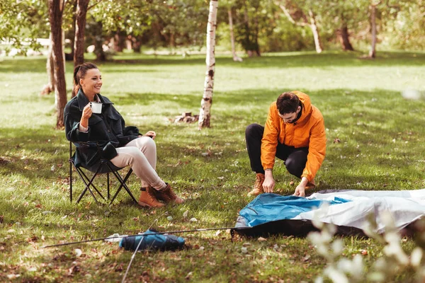 Pareja feliz armando tienda al aire libre — Foto de Stock