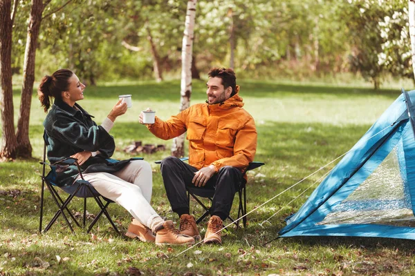 Šťastný pár pije čaj na táboře stan — Stock fotografie
