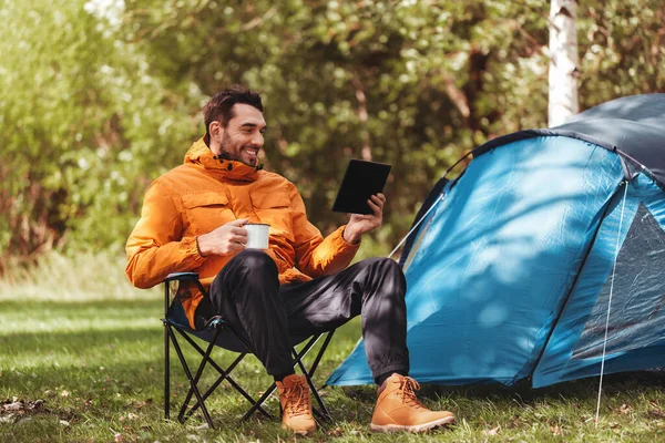 Hombre feliz con la PC tableta beber té en el campamento de la tienda —  Fotos de Stock