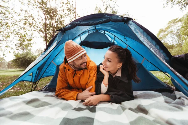 Feliz pareja acostada dentro de la tienda en el camping —  Fotos de Stock