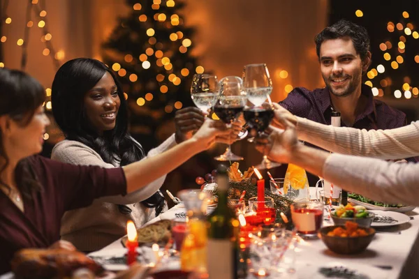 Amigos felizes bebendo vinho na festa de Natal Fotos De Bancos De Imagens