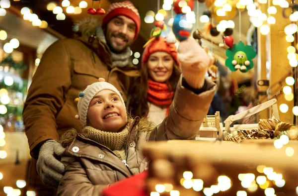 Щаслива сім'я купує сувеніри на різдвяному ринку — стокове фото
