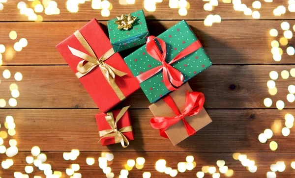 Noel hediyeleri ahşap tahtalarda ışıklar üzerinde — Stok fotoğraf