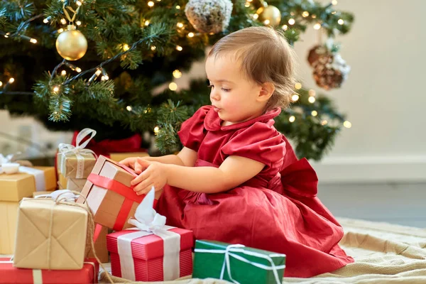 Glad liten flicka öppna julklappar hemma — Stockfoto
