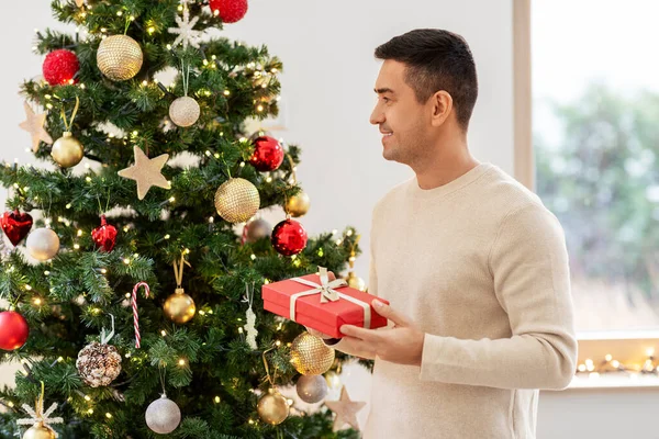 Szczęśliwy mężczyzna w średnim wieku z prezentem świątecznym w domu — Zdjęcie stockowe