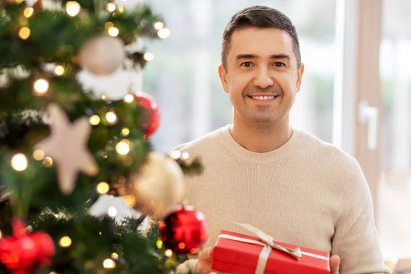 Happy middle aged man with christmas gift at home — Stock Photo, Image