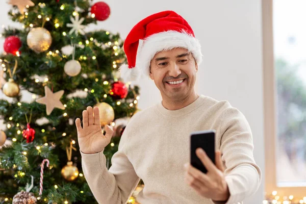 クリスマスにビデオ通話をするスマートフォンを持った男 — ストック写真