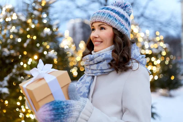 Szczęśliwa młoda kobieta z Christmas prezent zimą — Zdjęcie stockowe