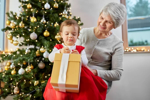 Бабушка и девочка с рождественским подарком — стоковое фото