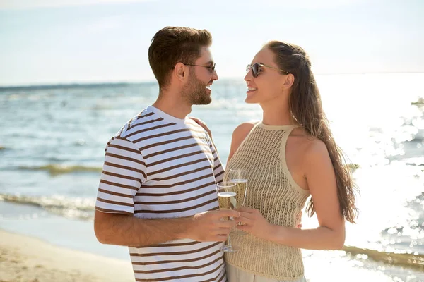 Lyckliga par dricker champagne på sommarstranden — Stockfoto