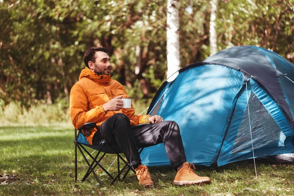 Homem feliz bebendo chá no acampamento da barraca — Fotografia de Stock