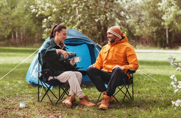 Feliz pareja bebiendo té en tienda campamento — Foto de Stock