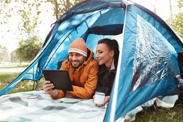 Пара с планшетным ПК пить чай в палатке — стоковое фото