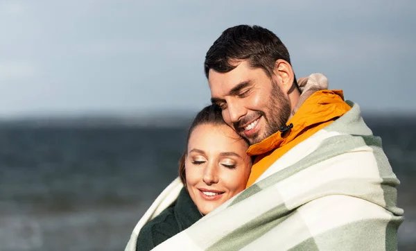 Sonbahar kumsalında sıcak battaniyeli mutlu çift — Stok fotoğraf