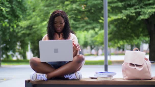 Chica estudiante africana con portátil y libros en la ciudad — Vídeo de stock