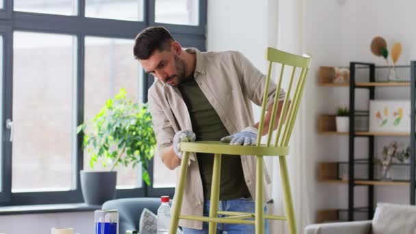 Man met vodden schoonmaken oude stoel voor renovatie — Stockvideo