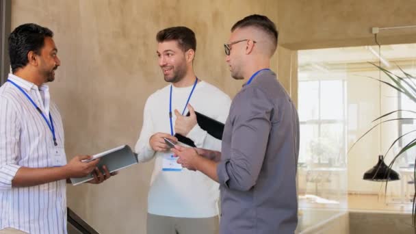 Hombres de negocios con etiquetas de nombres hablando en la oficina — Vídeos de Stock