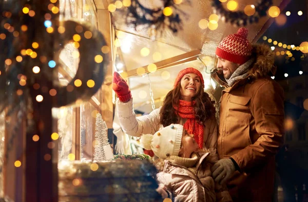 Счастливая семья на рождественском рынке в городе — стоковое фото