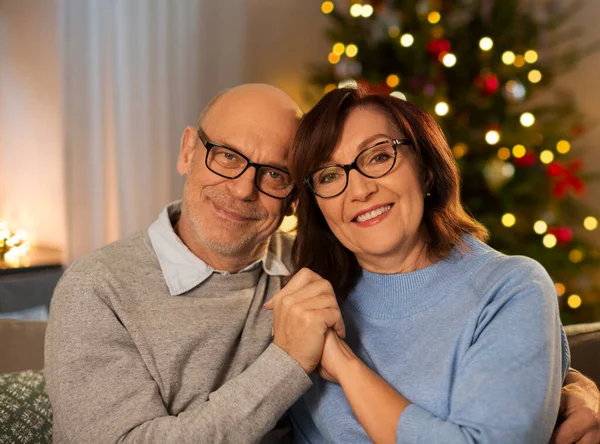 Felice coppia anziana che si abbraccia a casa a Natale — Foto Stock