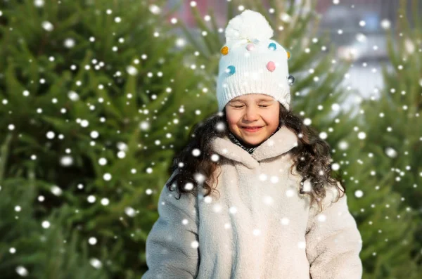 Happy little girl in winter clothes over snow — Stock Photo, Image