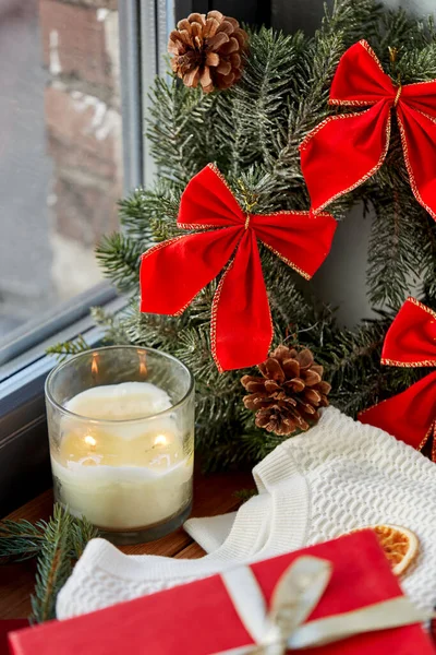 Grinalda de Natal e vela no peitoril da janela em casa — Fotografia de Stock