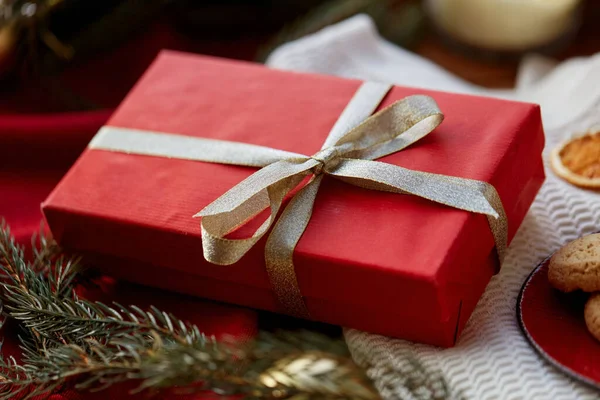 Christmas gift in red wrapping with golden bow — Stock Photo, Image